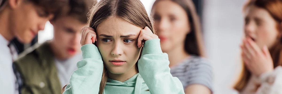 A young girl looking anxious and withdrawn at school