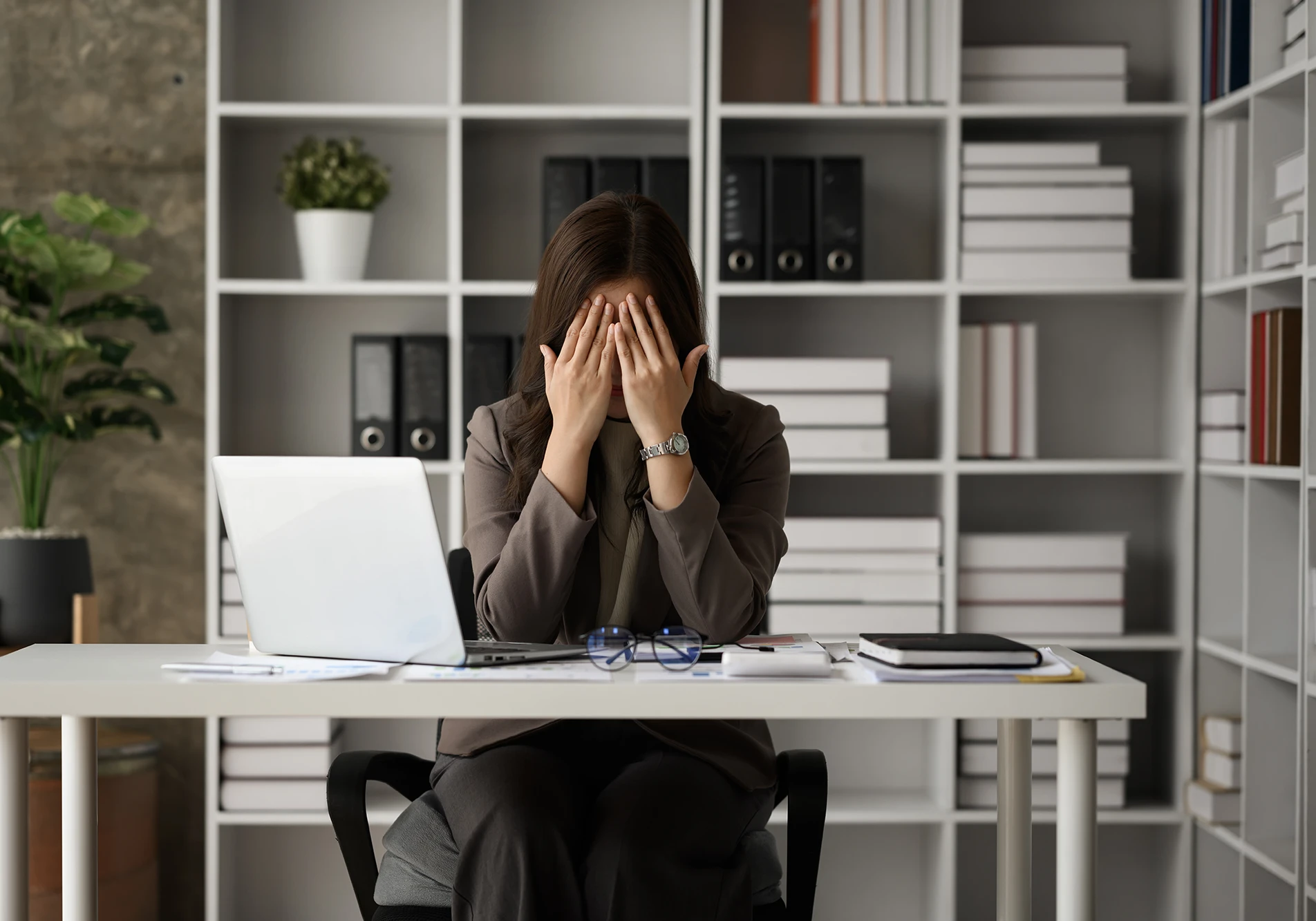 A woman at her desk feeling the weight of anxiety and outside pressure